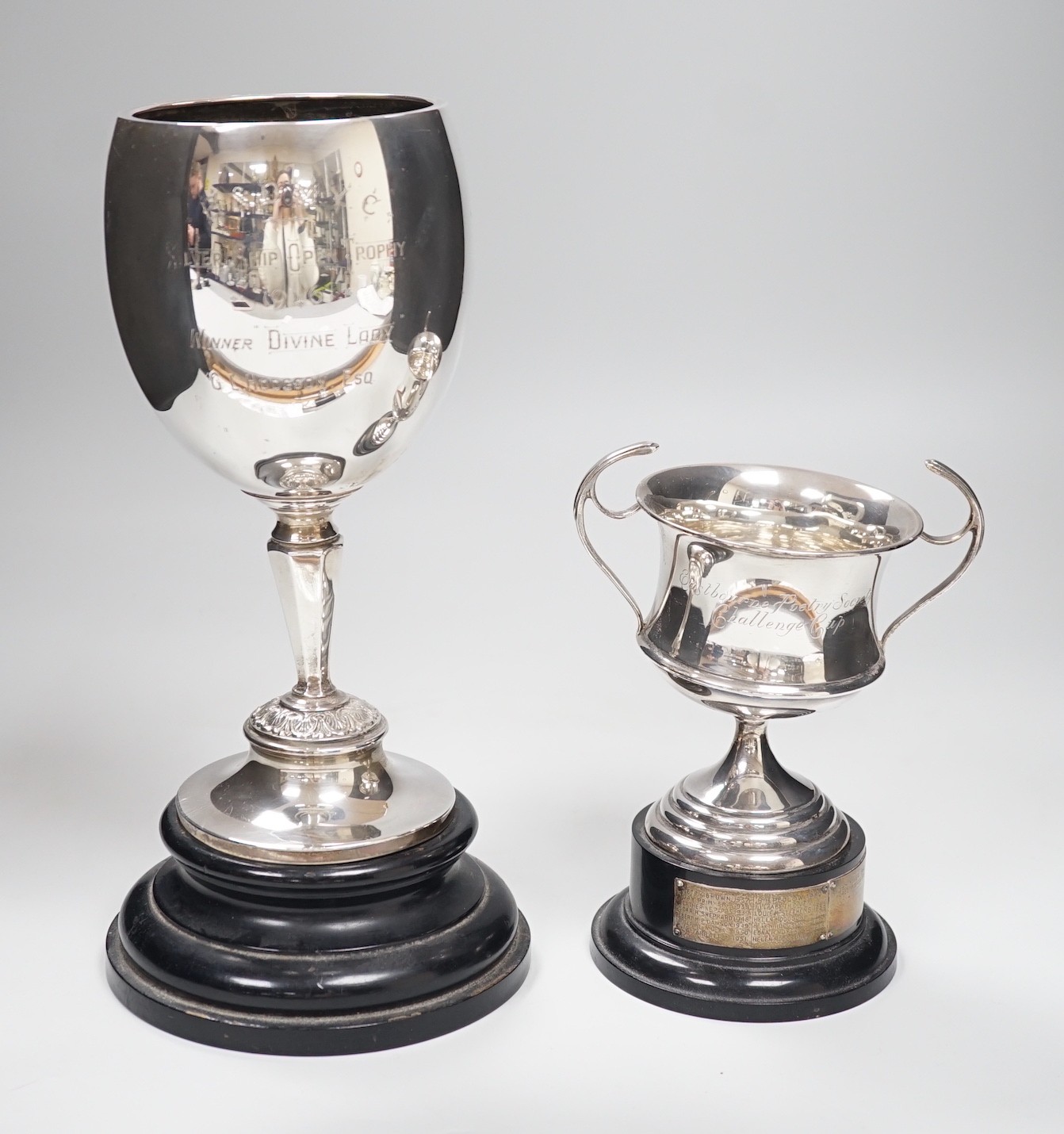 A silver trophy cup inscribed 'Winner Divine Lady', Birmingham 1932, 24.5cm, 10oz and a smaller two handled trophy cup 'Eastbourne Poetry Society Challenge Cup' (London 1914), 5oz